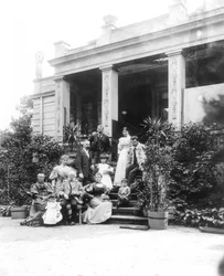 Max Klinger (1857–1920, oben links im Foto) mit seiner Familie vor dem Haus seiner Eltern in Leipzig, Karl-Heine-Straße 2 (Gartenseite)